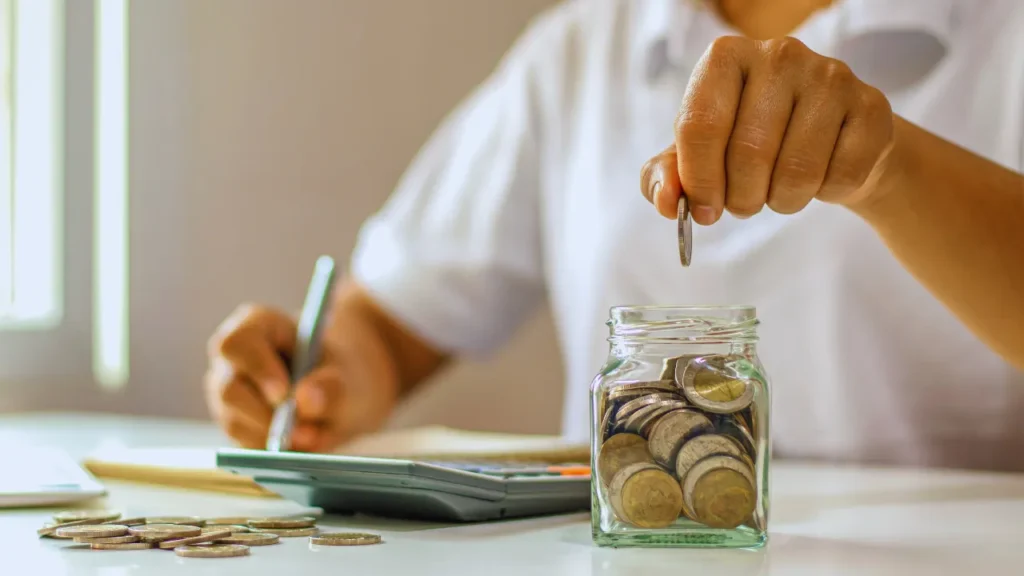 Cofrinho cheio de moedas com plantas crescendo dele, mostrando como pequenas economias diárias podem florescer em grandes resultados financeiros com o tempo.